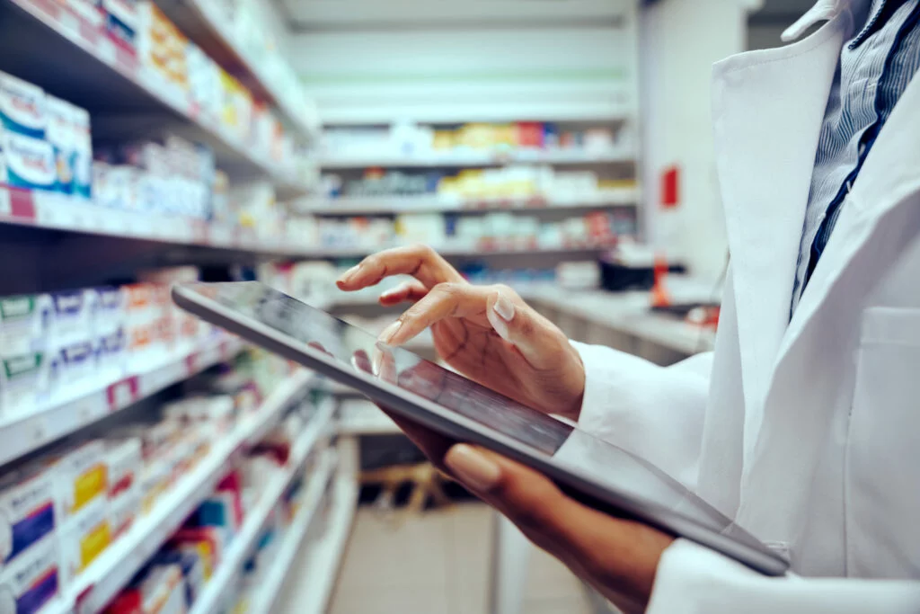 Closeup of hands of young female pharmacist checking inventory in medical store using digital tablet stock photo1 1024x683