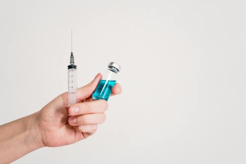 A gloved handed holding vaccine syringe .jpg